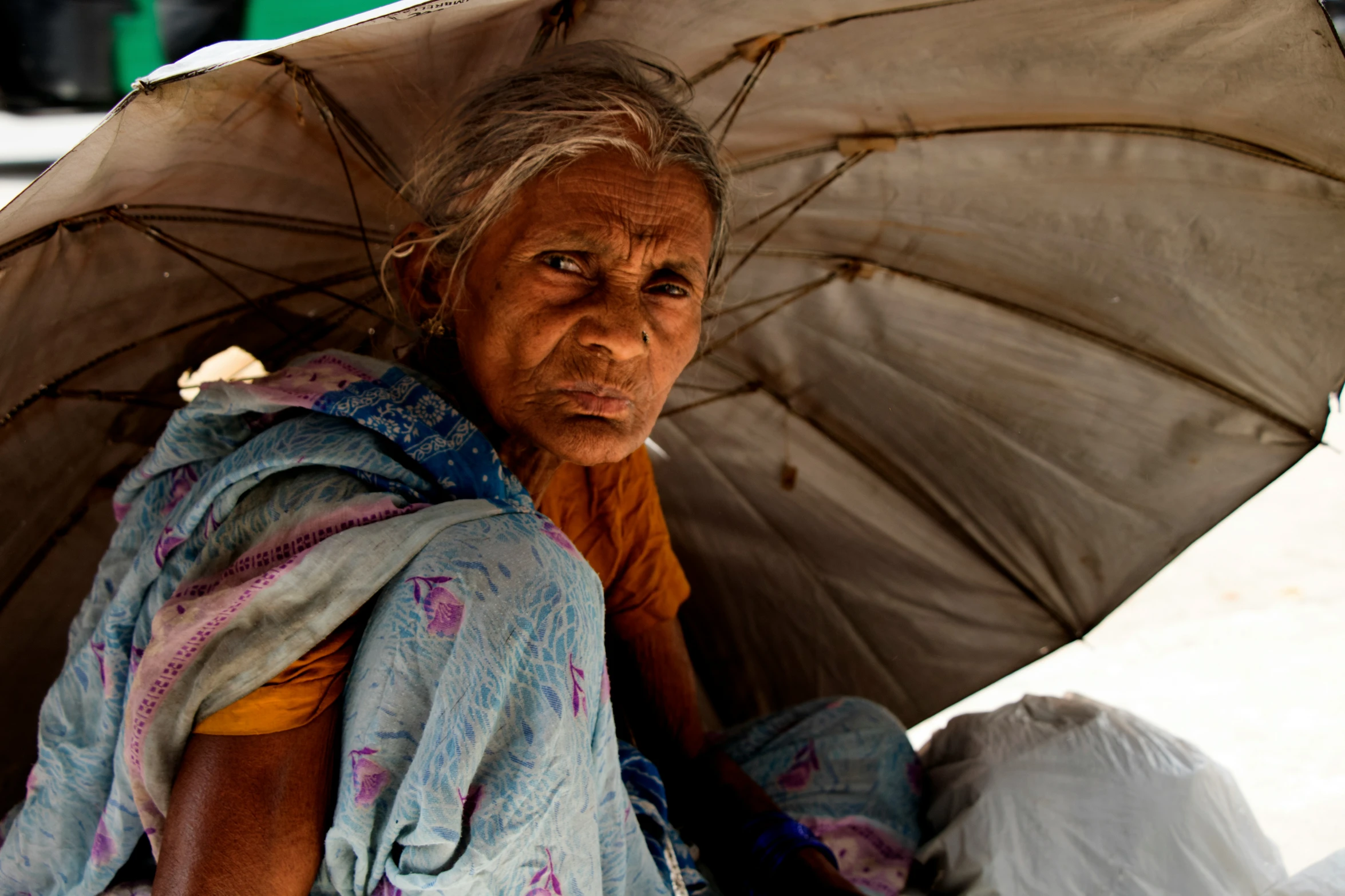 the old woman is sitting in the shade