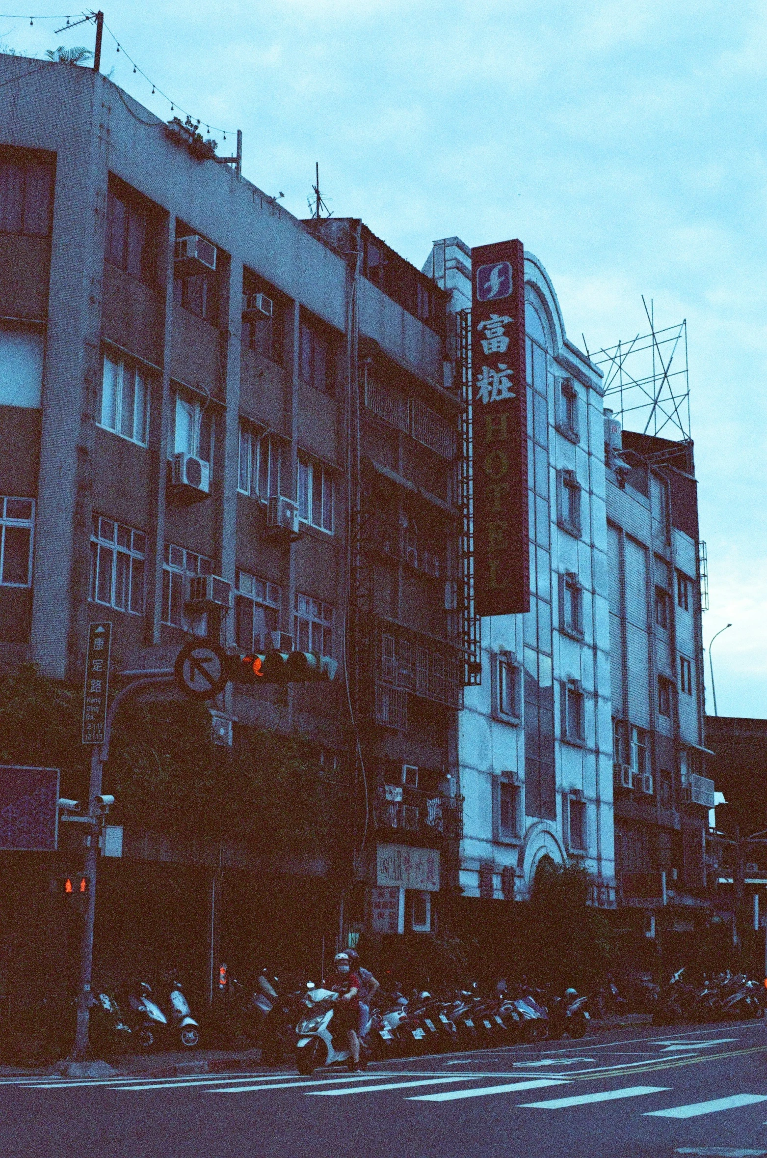 a night view of some very tall building and motorcycles parked by