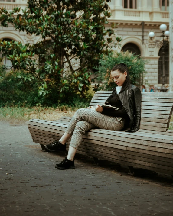 a person sitting on a bench holding a book