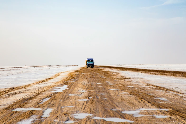 a truck travels along the open plains on a cold, winter day