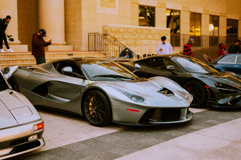 the four sports cars have been parked on the side of a building