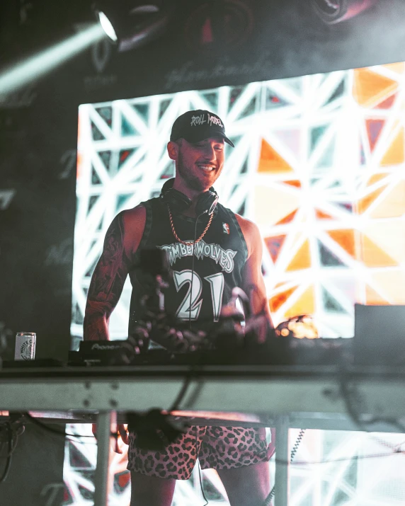 a man standing in front of a stage holding his hands behind his hipster's head