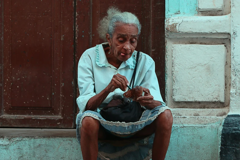 an old person sits outside on a step