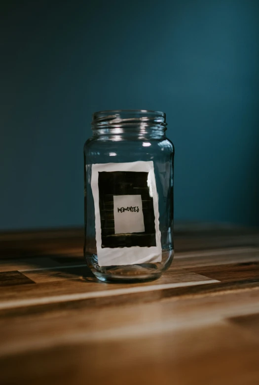 a glass jar with a note sitting on a wooden table