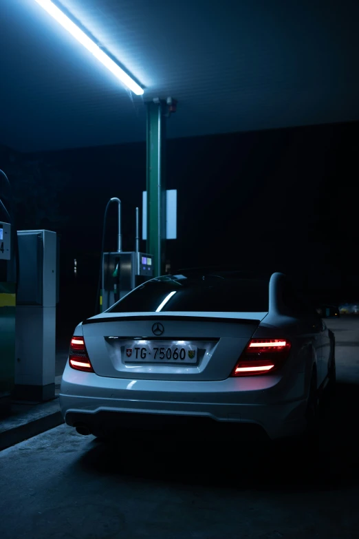 the rear end of a car at night in a garage