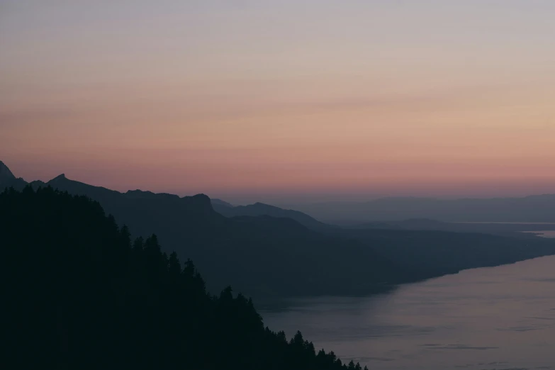 two people on mountains looking over a lake