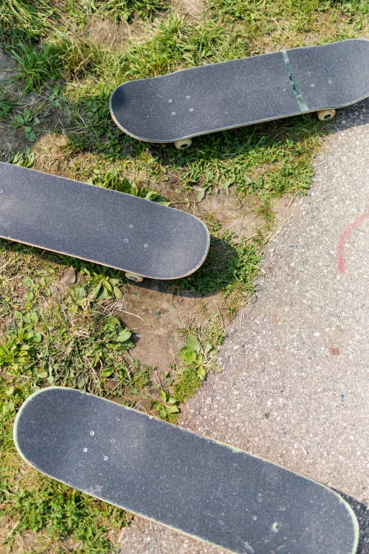 several skateboards on the ground with grass and dirt