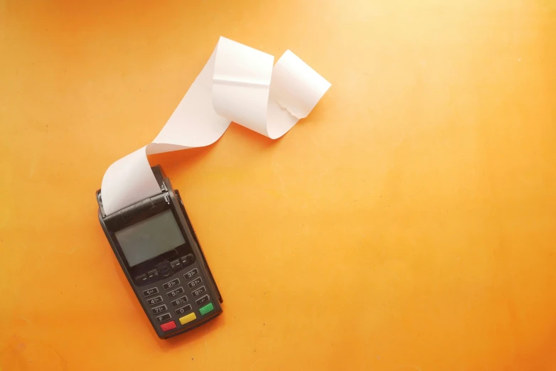 a cell phone sits on a table with paper