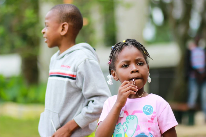 an image of children that are outside and one is eating soing