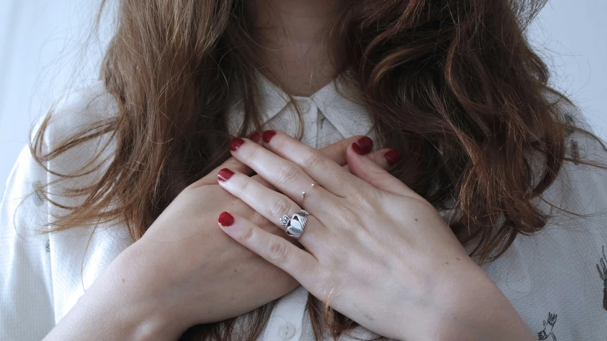 a close up of a woman holding her hands together