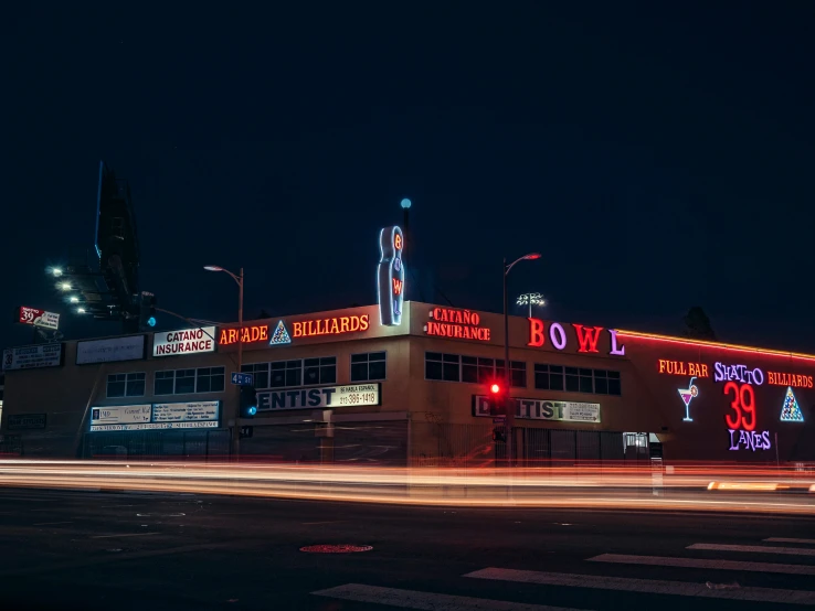 an old building has a sign and red neon lights in the city