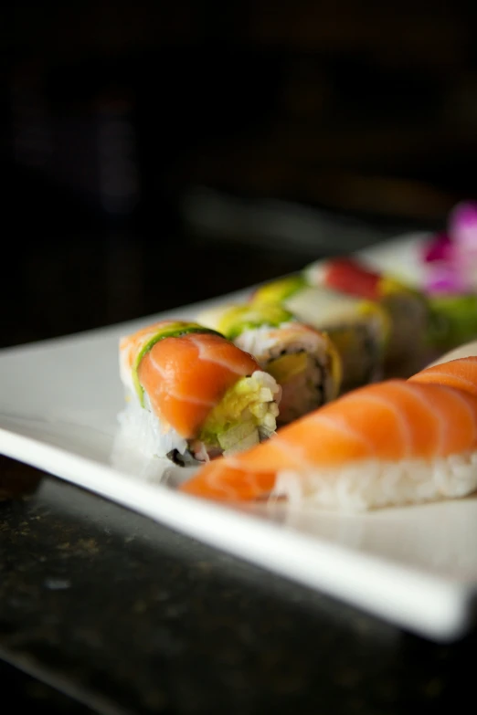 a dish of sushi with an assortment of meat and veggies