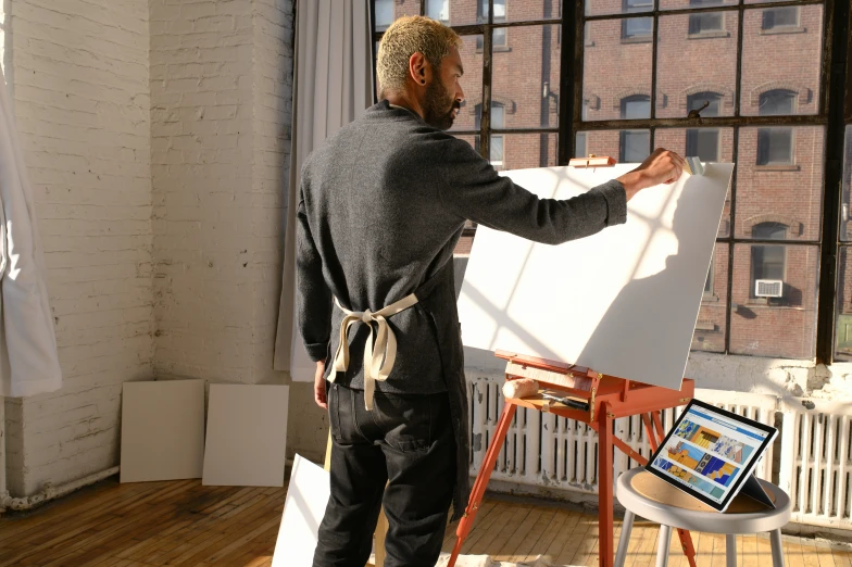 a man standing in front of a easel with a whiteboard in his hand