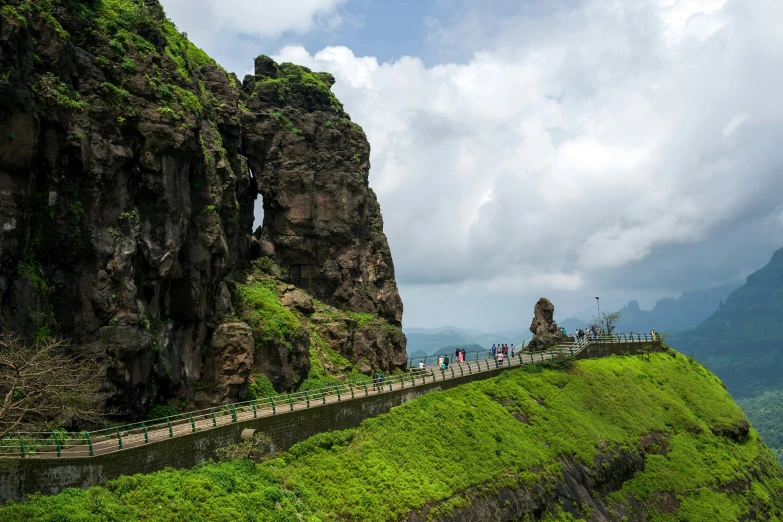 tourists walk the walkway over the hill to admire the incredible scenery