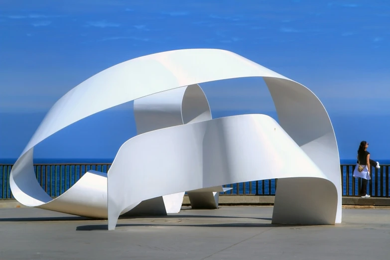 a very large white sculpture by the water