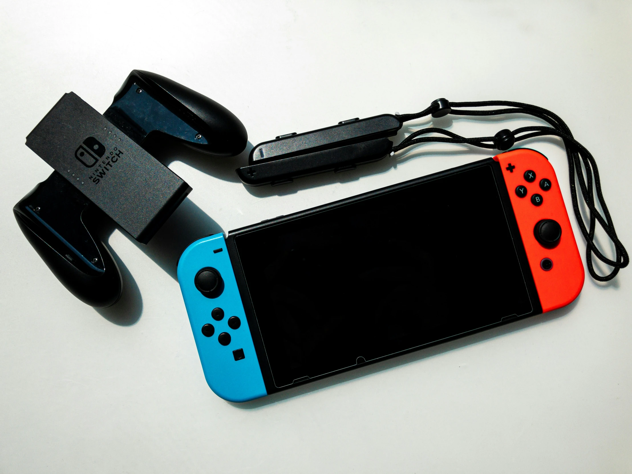 an orange and blue nintendo switch laying on a white table