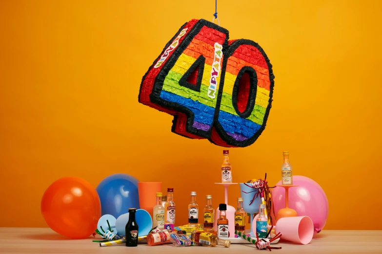 a number four birthday cake hanging above colorful balloons