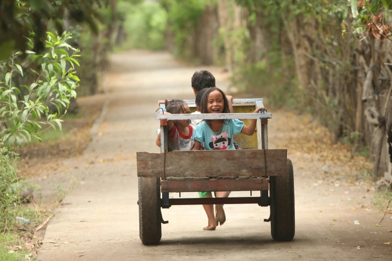 an indian family traveling in a cart down a dirt road