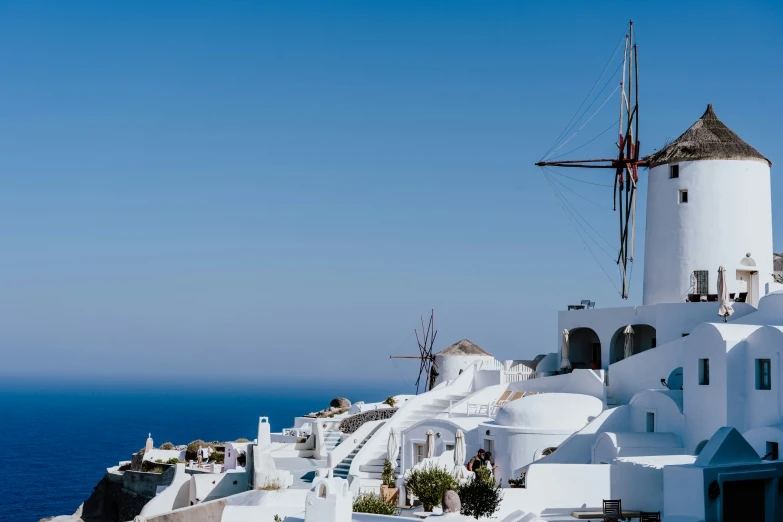 a view of a cliff with several buildings and an old windmill