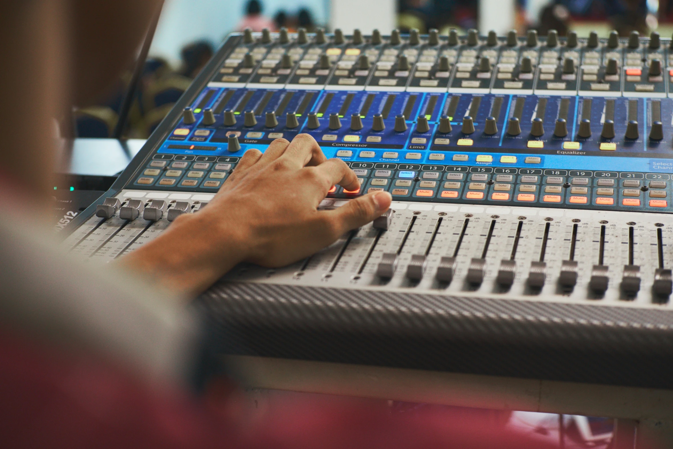 a person using the mixing console for an audio mixing and recording studio