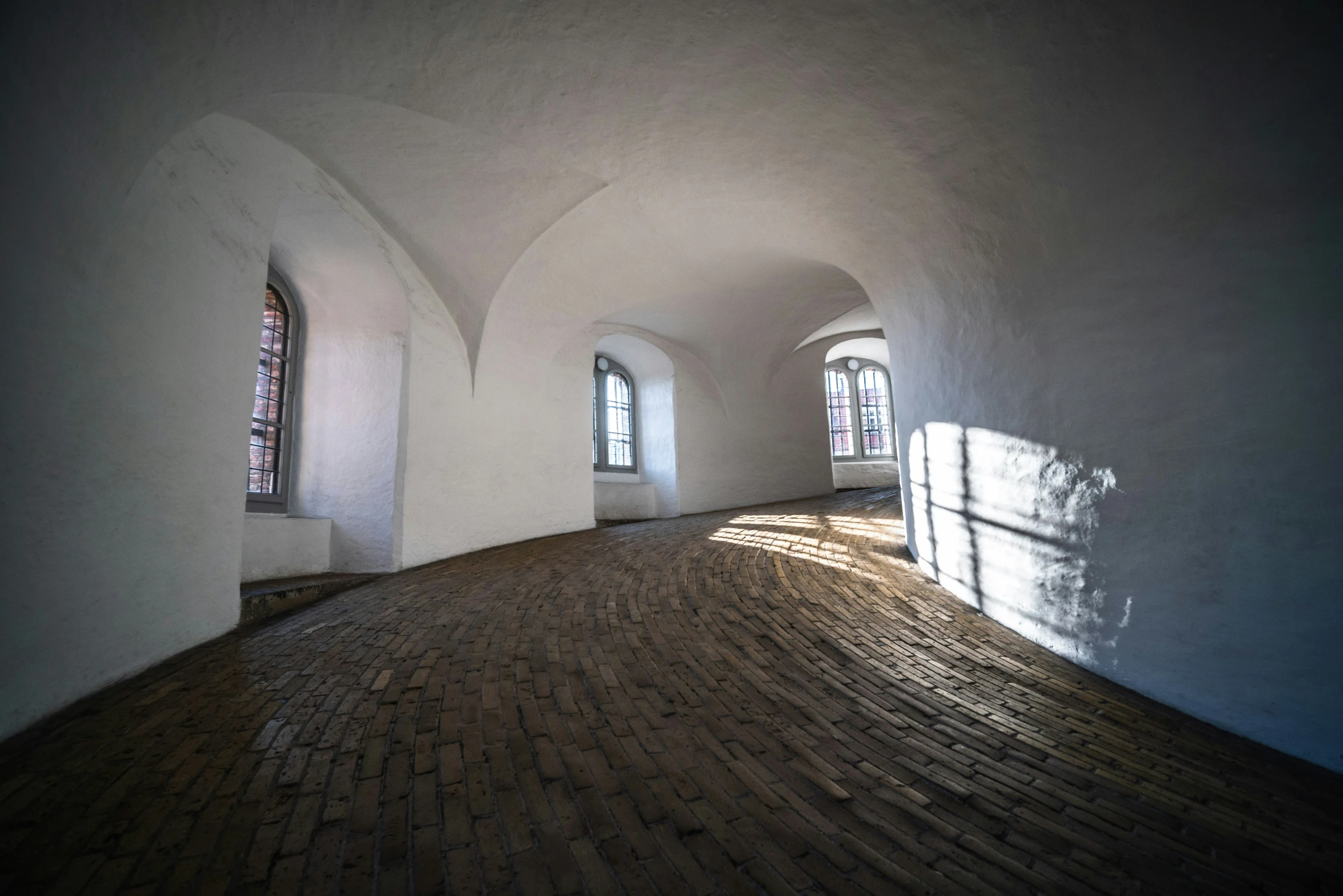 empty room with brick floor and arched windows