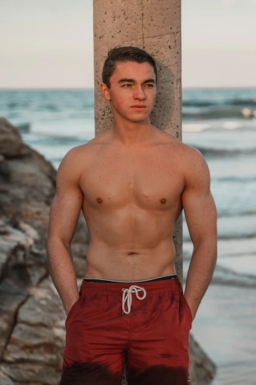 a man standing near a water tank in a red pants