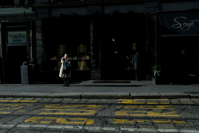 a woman walks down the sidewalk at night