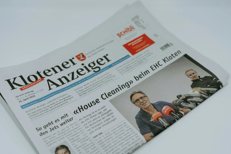 the front page of the news is showing a close up view of two people in a black shirt