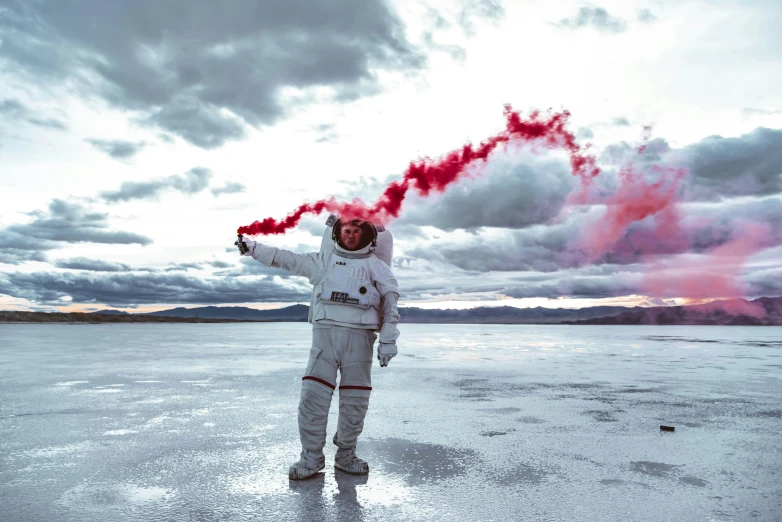 a person is standing in the snow holding red smoke