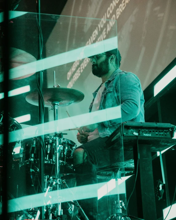 man with a beard playing drums at a music event