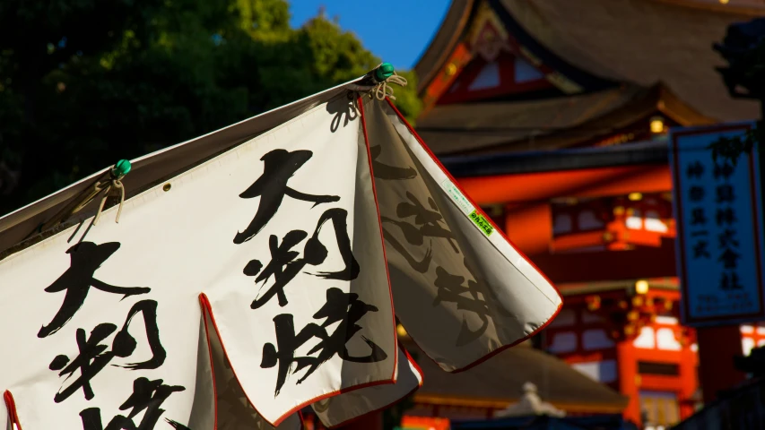 an asian sign hangs near some red and white buildings