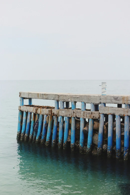 an old fishing pier has blue posts