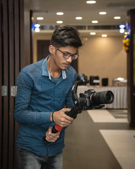 a man wearing glasses while holding a camera