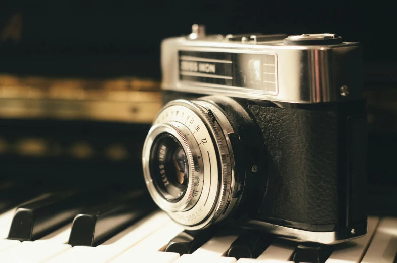 an old camera sitting on a piano