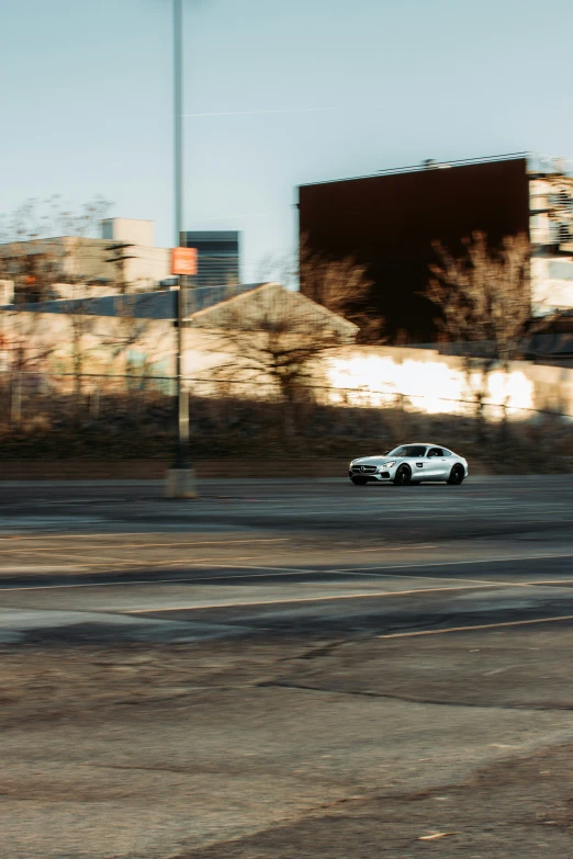 a white car driving down the street in front of buildings