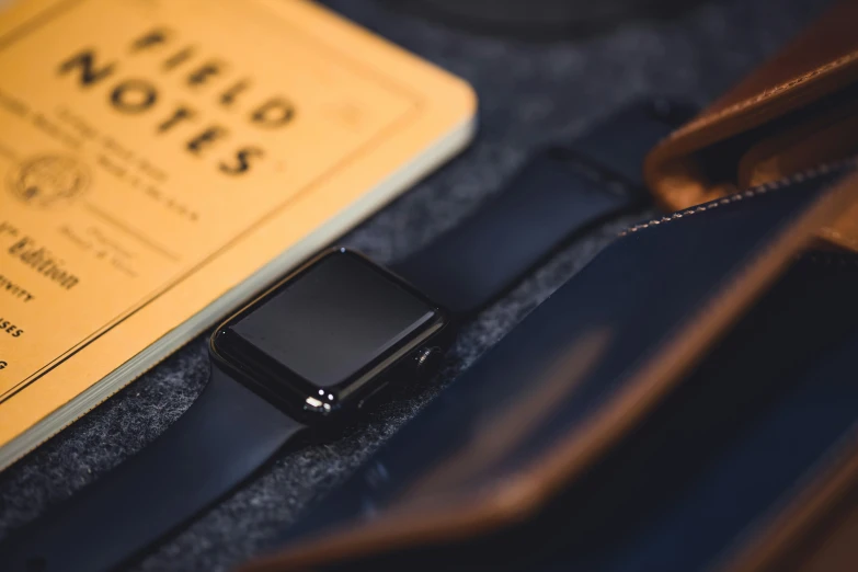 there is a small leather wristband and book on the table