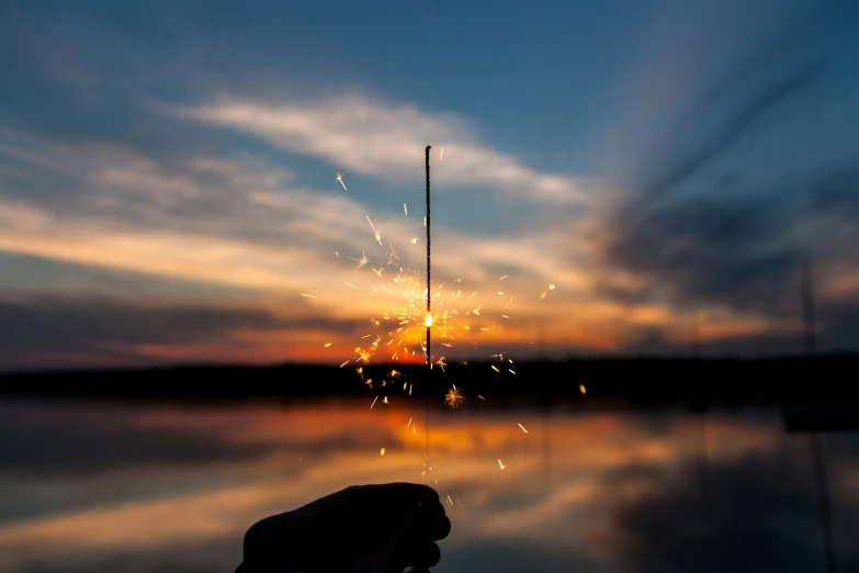 a view of firework and water with a sky in the background
