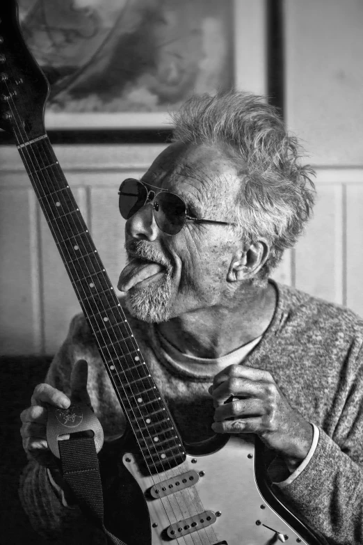 black and white pograph of an old man with a guitar