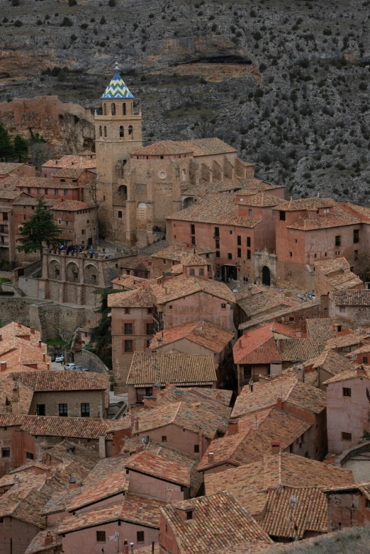 some very pretty brown colored buildings near a large hill