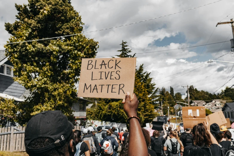 black lives matter sign being held by several people