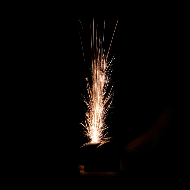 a person is holding a sparkler on a black background
