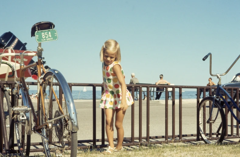 there is a little girl that is standing next to some bikes