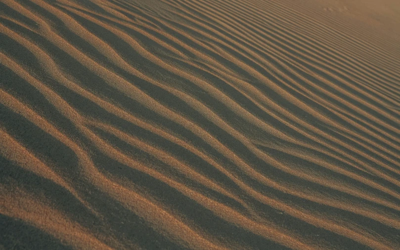 some brown sand and a few waves in the desert