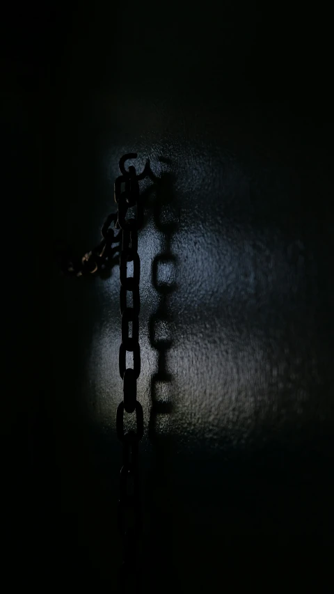 a chain is standing on the wall outside in the dark