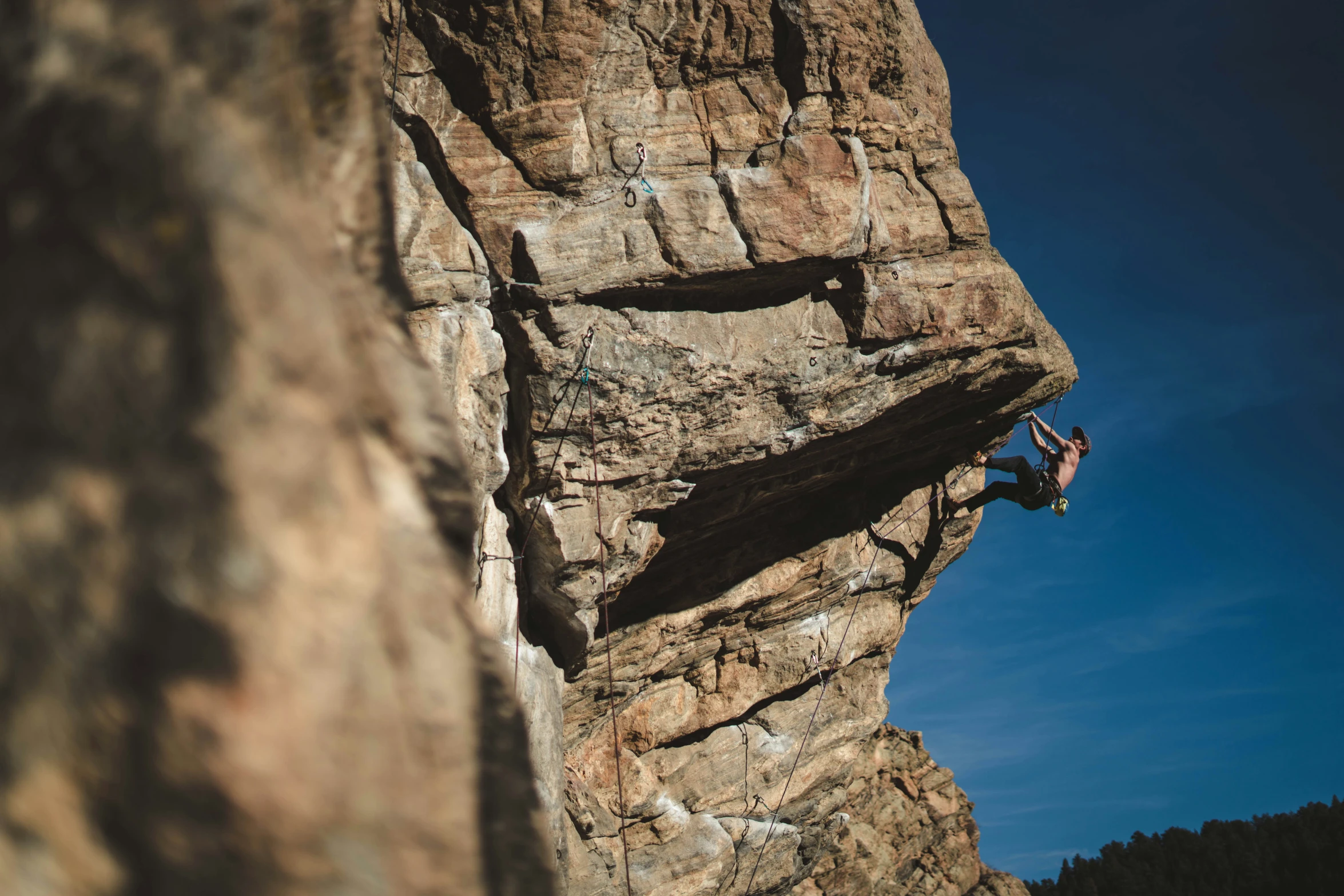 the man is rock climbing up a big mountain