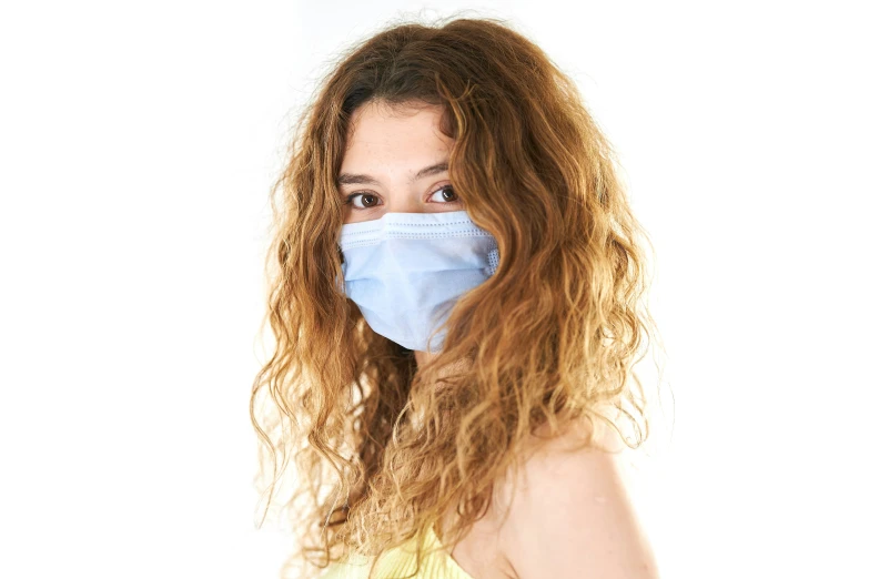 woman with long, curly hair wearing a blue mask