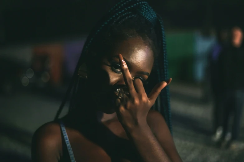 a black woman holding a finger to her face