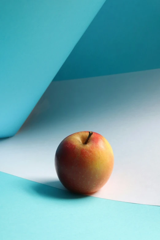 an apple is sitting on a white surface