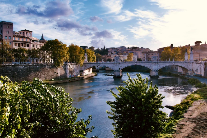 a bridge that has buildings in it and water in front