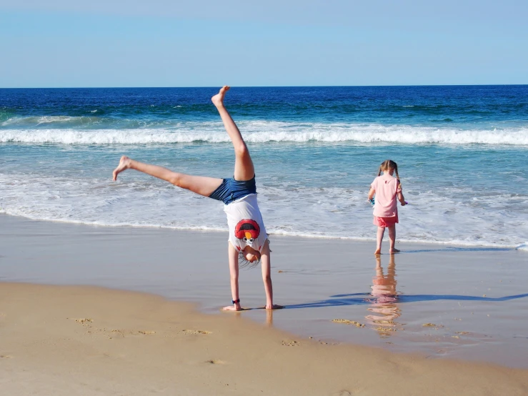 an image of two s playing at the beach